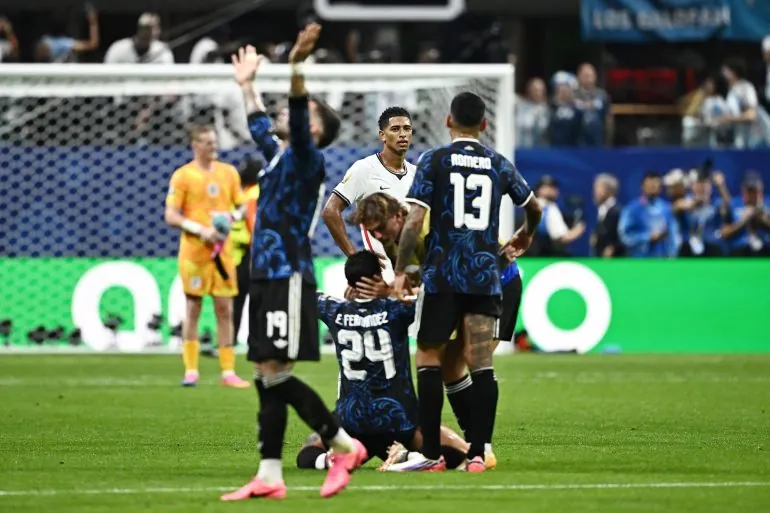 Soccer Football - FIFA World Cup 2026 - Semi Final - England v Argentina - Atlanta Stadium, Atlanta, Georgia, U.S. - July 15, 2026 Argentina's Enzo Fernandez, Cristian Romero and Nicolas Otamendi celebrate after the match as England's Jude Bellingham looks dejected REUTERS/Dylan Martinez