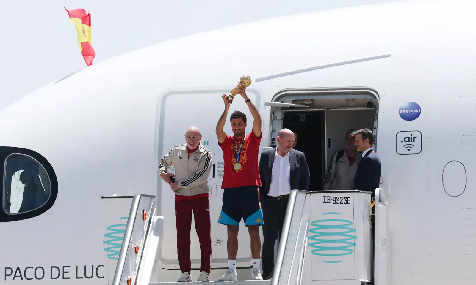 Spain's Rodri, coach Luis De La Fuente and Royal Spanish Football Federation President Rafael Louzan with the World Cup trophy during the team's arrival at Madrid on July 20, 2026.