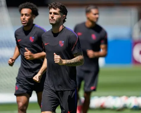 Christian Pulisic, wearing a dark blue top, runs with his US teammates during a training session